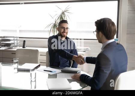 Smiling diverse businessmen making deal, satisfied with negotiations results. Stock Photo