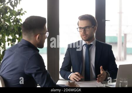 Focused young businessman in formal wear talking with partner. Stock Photo