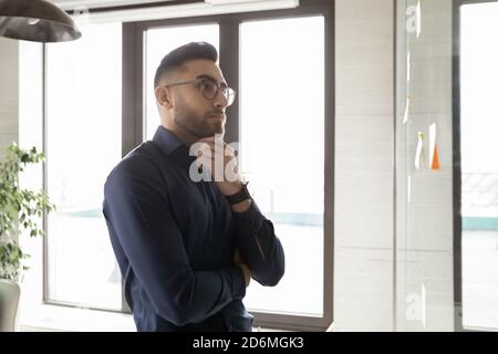 Pensive young arab middle eastern ethnicity young businessman solving problem. Stock Photo