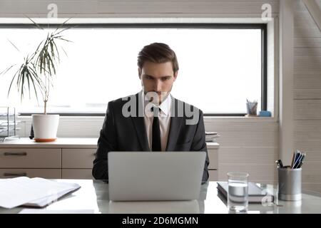 Confident serious young ceo executive male manager working on computer. Stock Photo