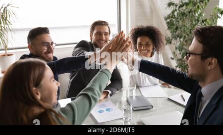 Positive happy young multiracial diverse colleagues giving high five. Stock Photo