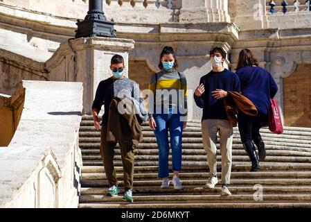 People wearing face masks descend the steps of Trinità dei Monti,In Italy, the increase in coronavirus is over 10,000 a day and has prompted the government to oblige protective masks on the streets and to take other measures to contain the pandemic. Stock Photo