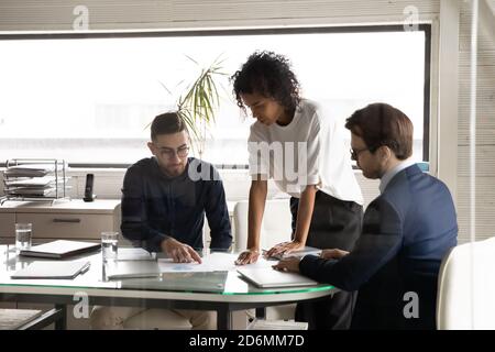 Focused young skilled african american businesswoman discussing salles with colleagues. Stock Photo