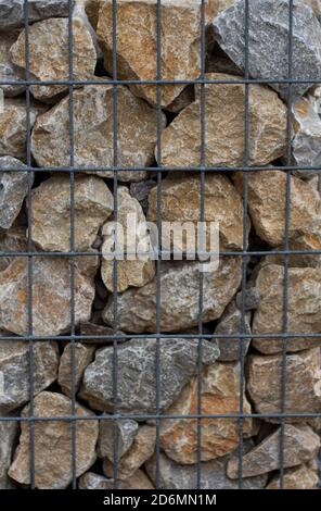 A fragment of wall made of wired cage filled with stones . Gabion wire mesh wall. Stock Photo