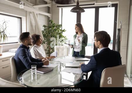Smiling young european female speaker reporting research results. Stock Photo