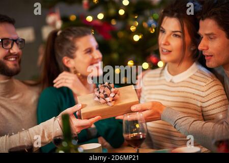 Group of friends with presents celebrating Christmas at home Stock Photo