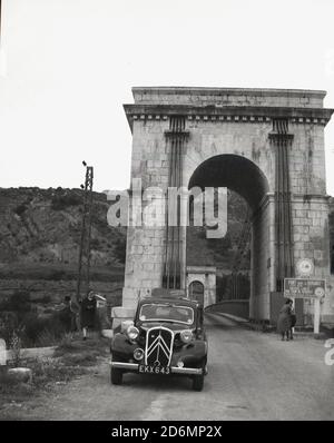 1950s, historical, a British motorcar of the era parked by the Pont Sur La Durance, a 19th century French suspension bridge built over the river Durance in the Provence -Alpes-Cote D'Azur region of France. Stock Photo