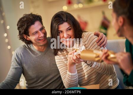Group of friends celebrating Christmas by pulling crackers Stock Photo