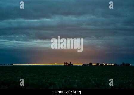 Clouds are illuminated by the light from greenhouses in the west of the Netherlands Stock Photo