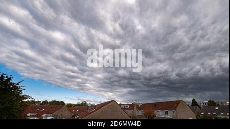 Dramatic sky with mammatus or bubble clouds over a dutch town Stock Photo