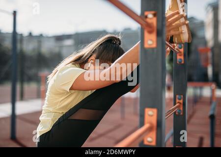 Muscular woman doing flexible gymnast outdoors Stock Photo