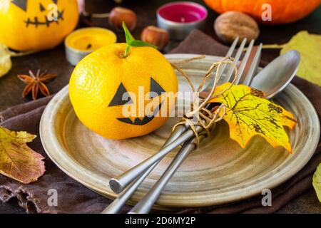 Halloween wooden table setting with pumpkins and tangerines. Stock Photo