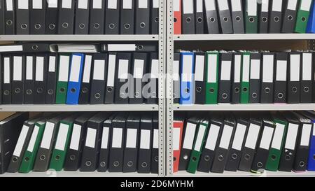 A lot of folders in the office shelf: papers, documents and catalogs. Stock Photo