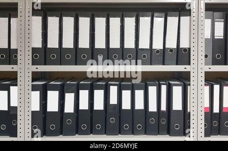 Office shelf with a lot of folders. Papers, documents and catalogs. Stock Photo