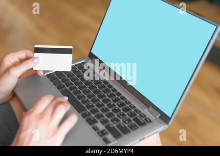 Vemale hands with a laptop and a credit card. Online shopping concept. Stock Photo