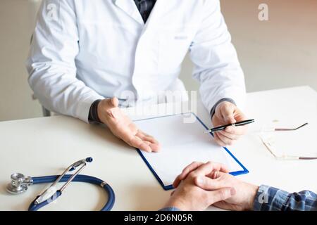 Doctor tells the patient about his illness and the possibilities of his medical insurance. Patient and doctor. Health Care Concept. Stock Photo