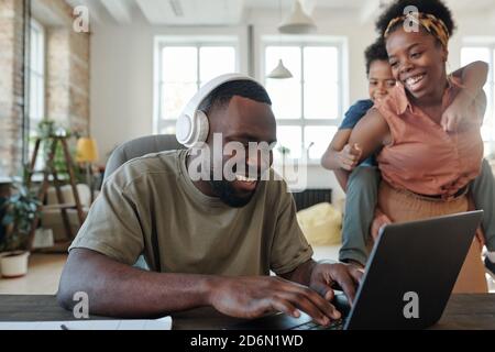 Happy young wife of home office manager and their cute little son having fun Stock Photo