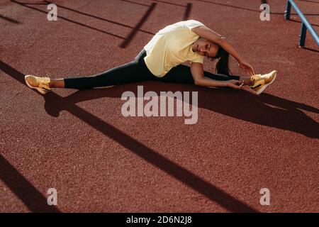 Sporty woman sitting on split twine and doing exercises Stock Photo
