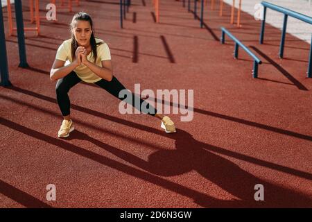 Attractive young brunette training legs outdoors Stock Photo
