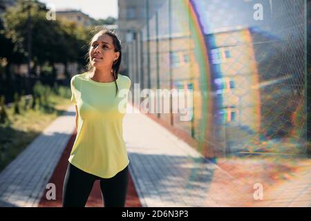 Front view of young brunette stretching hands outdoors Stock Photo