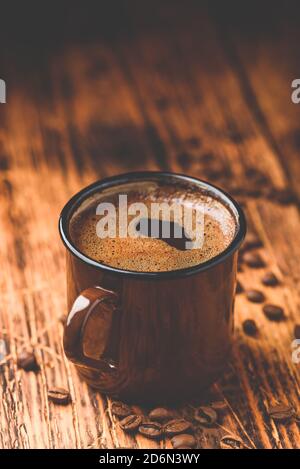 Brewed black coffee in metal mug Stock Photo