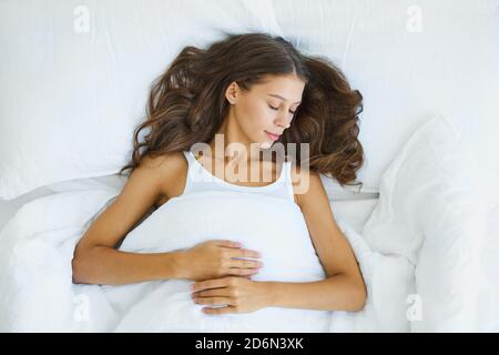Top view waist portrait of beautiful sleeping woman in bed. Female with long hair resting Stock Photo