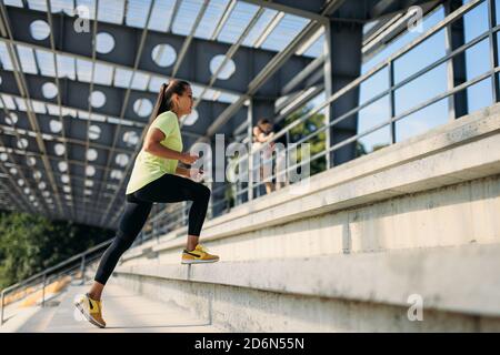Beautiful female athlete doing exercises at city stadium Stock Photo