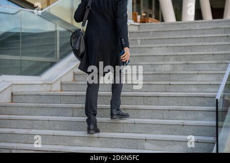 Back view of contemporary elegant businessman going to business center for work Stock Photo