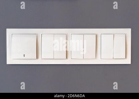 white plastic light switch on gray wall Stock Photo