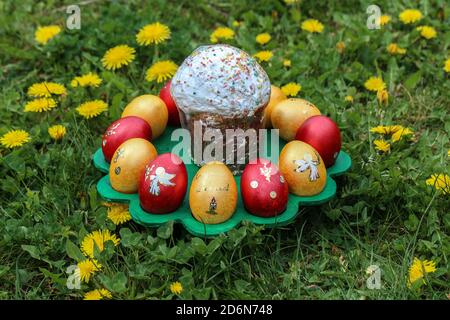 High angle closeup shot of an Easter cake surrounded by colorful eggs Stock Photo