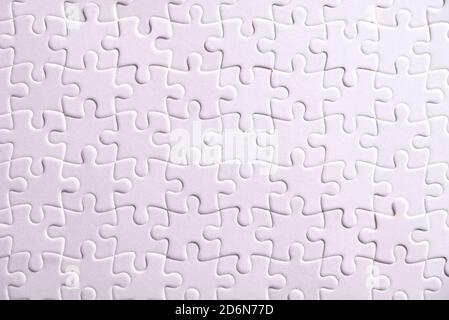 Puzzle background, white puzzle consists of many pieces Stock Photo