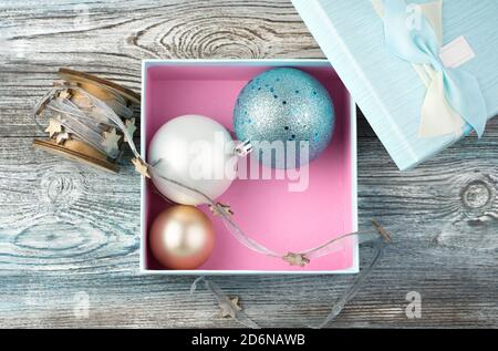 Christmas balls in a blue box on a wooden background. Stock Photo