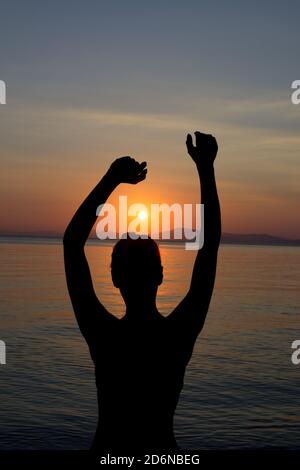 Beautiful Woman Sihlouette in Dancing Pose in front of Sunset Stock Photo