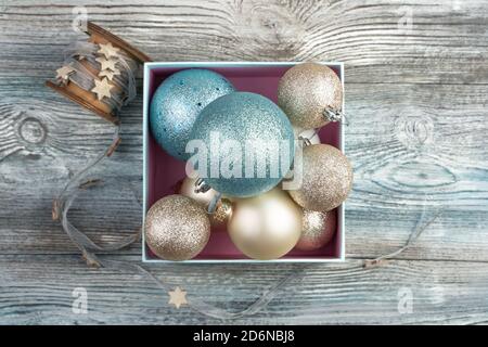 Many different Christmas balls and a ribbon with stars on a wooden gray background. Stock Photo