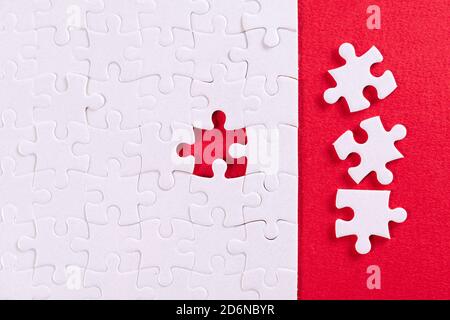 Plain white jigsaw puzzle, on Red background Stock Photo