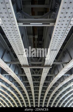 Beneath Blackfriars Railway Bridge and station in London, UK. The strong steel beams with rivets underneath the bridge hold the structure in place. Stock Photo