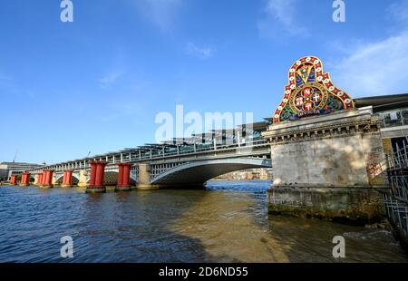 Old and new Blackfriars railway bridges in London, UK. Old bridge has only the red supports and abutment remaining. New bridge and station behind. Stock Photo