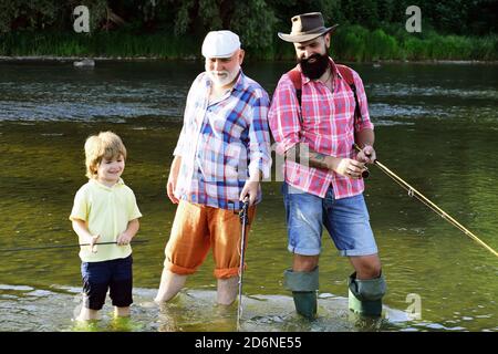 Man in different ages. Father and son fishing. Happy fisherman with fishing rod. Hobby and sport activity. Anglers. Stock Photo