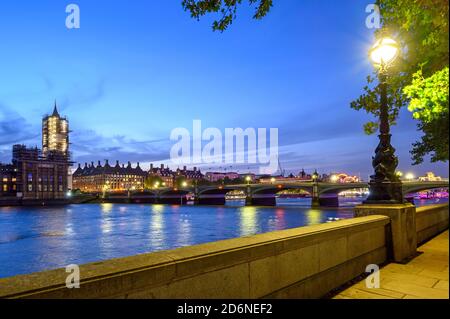 View of Westminster and the River Thames in London, UK. The Houses of Parliament and Big Ben are to the left. A red bus crosses Westminster Bridge. Stock Photo
