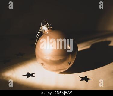 Close-up of one Christmas bauble on a flat surface with stars. High contrast Image,matte and sepia colored Stock Photo