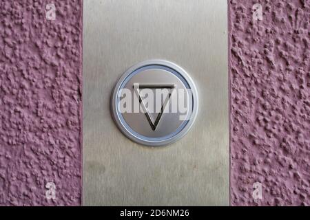 close up of an elevator button on a violet wall Stock Photo