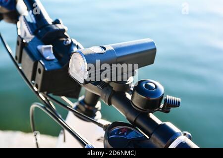 Close-up of bicycle front light and bell on a handlebar. Bicycle accessories. Stock Photo
