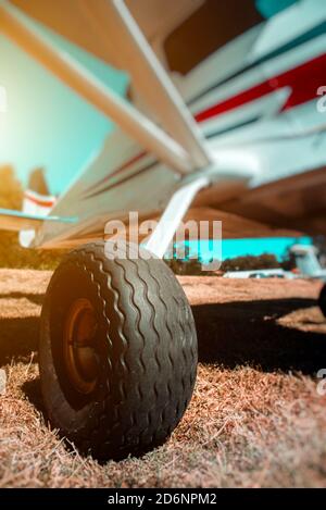 Small plane on grass runway wheel close-up Stock Photo