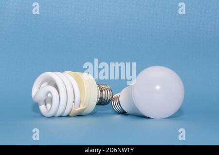 Old dirty fluorescent and new led lamps on blue background Stock Photo