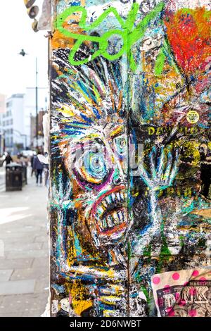 Walls covered in graffiti, posters and artwork by Brick Lane, East London, UK Stock Photo