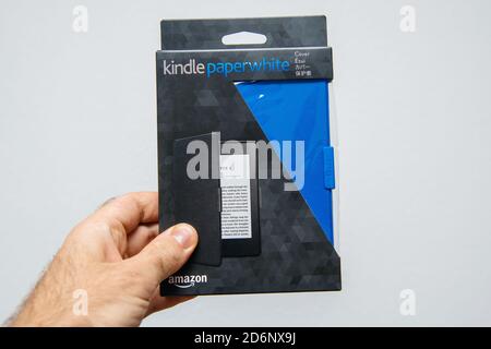 Paris, France - Mar 14, 2018: Male hand holding package of new Amazon Kindle Paperwhite cover package before unboxing Stock Photo