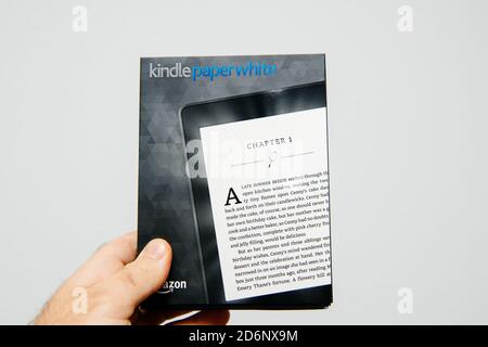 Paris, France - Mar 14, 2018: Male hand holding package of new Amazon Kindle Paperwhite package before unboxing Stock Photo
