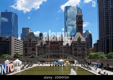 TORONTO, CANADA - 06 27 2016: View across the fountain on Nathan Phillips Square with Old City Hall and Cadillac Fairview Tower in the background Stock Photo