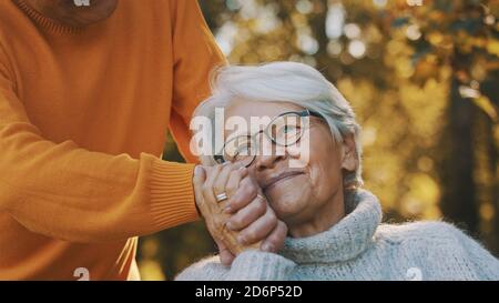 Old couple having romantic autumn day in forest. Hugging tree and smiling. High quality photo Stock Photo