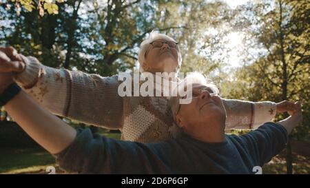 Happy old enjoying day in park. Senior man flirting with elderly woman. Dance in autumn day. High quality photo Stock Photo